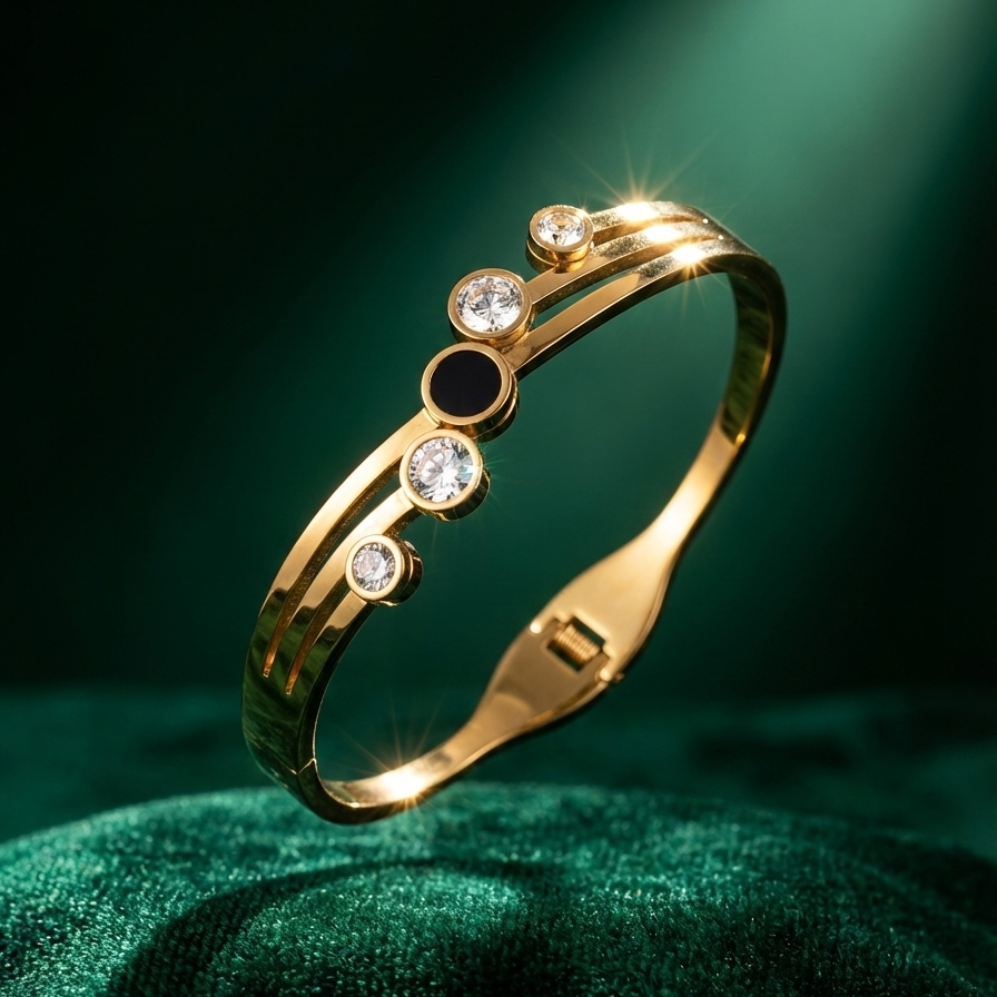 Gold hinged bangle bracelet with black stone and crystal circles on white stand.