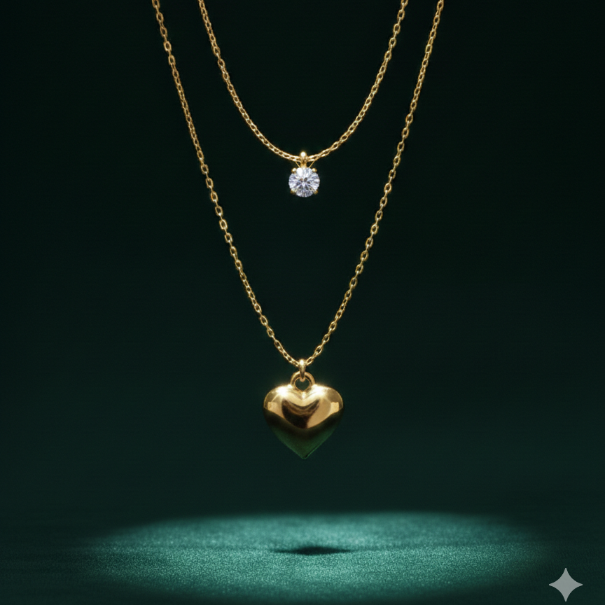 Double layered gold necklace with crystal solitaire and puffy heart pendant on beige plate.