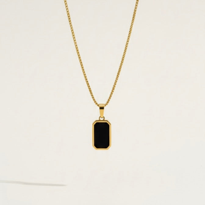 Reversible rectangular gold pendant necklace showing black side on model neck.