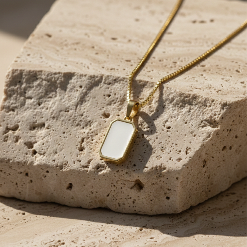 Reversible rectangular gold pendant necklace showing black side on model neck.