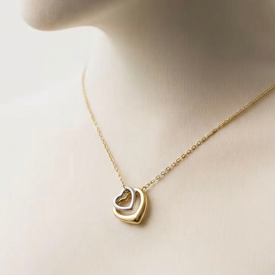 Gold necklace with a heart-shaped pendant on a mannequin.