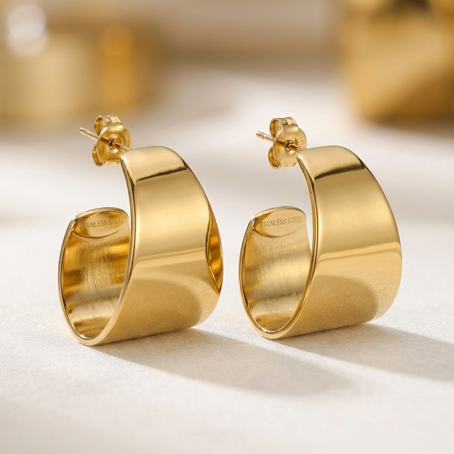 18kt gold plated wide sculpted earrings on a light background.